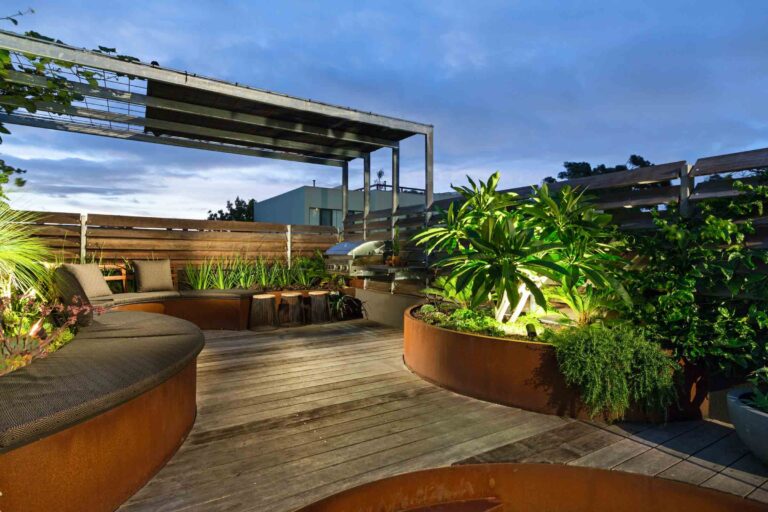 Curved corten steel seating and planters on timber deck rooftop terrace with city views in Albert Park Melbourne