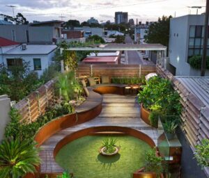 Multi-level rooftop garden with curved corten steel seating, circular conversation pit and layered planting in Albert Park