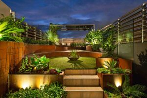 Multi-level rooftop garden with curved corten steel seating, conversation pit and tropical planting in Albert Park Melbourne