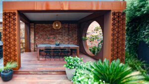 Corten steel pergola with geometric screening sheltering outdoor dining area in Brighton East modern courtyard design