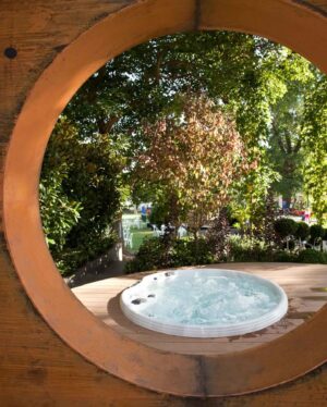 Circular timber frame around white spa with garden view in The Conversation Garden, Melbourne International Flower & Garden Show