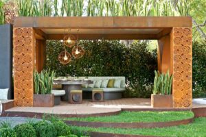 Contemporary timber pavilion with perforated Corten steel screens and pendant lighting at Melbourne show garden