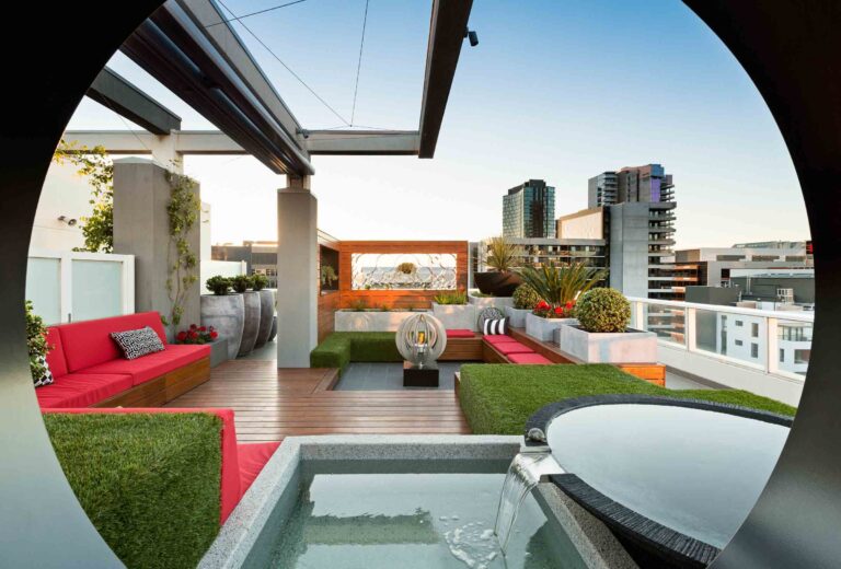 Modern rooftop terrace with integrated water feature, timber decking and city views in Docklands Melbourne