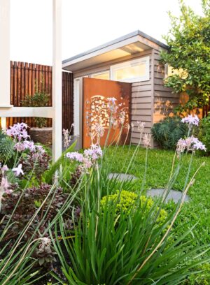Laser-cut corten steel screen with circular pattern creates privacy in compact Hawthorn East courtyard garden