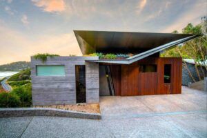Modern home with dramatic cantilevered roof, concrete and timber cladding, green roof plantings at Separation Creek