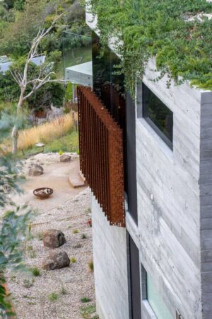 Perforated corten steel staircase descending through concrete architecture at Horizon house, Separation Creek