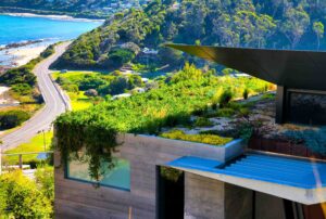 Tiered corten steel retaining walls creating outdoor living spaces on steep coastal site at Separation Creek