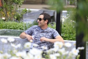 Man in sunglasses sitting at table in award-winning Mandala Moon Gate Garden at Gardening World Cup Nagasaki
