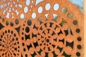 Custom laser-cut corten steel decorative screen with circular and floral patterns in Buninyong modern native garden