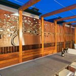 Laser-cut corten feature screen behind outdoor dining setting in modern Melbourne courtyard.
