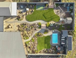 Top-down landscape masterplan render of Gisborne residence showing deck, pool, lawns, pathways, and planting zones.