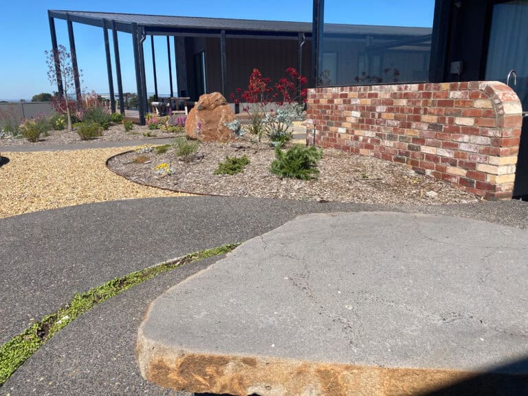 Basalt Feature in gardens with brick feature wall and planting at Gisborne home.