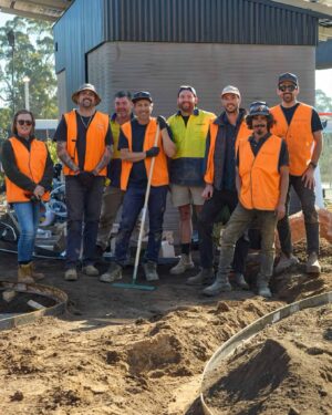 Construction crew in high-vis safety vests posing together during landscape construction work at The Block Daylesford