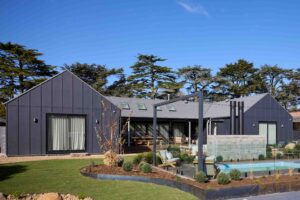Modern dark grey home with glass-fenced swimming pool and landscaped garden in Daylesford, Victoria