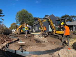 Construction crew with mini excavator and curved pool installation at The Block Daylesford House 5 project site