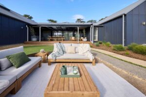Modern outdoor entertaining area with timber furniture and steel pergola at Daylesford House 5 project