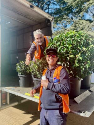 Two landscaping team members in high-vis vests celebrating with thumbs up at The Block Daylesford House 5 project site