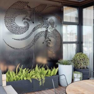 Perforated steel privacy screens with flowing bird design on St Kilda rooftop terrace with planters and city views