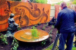 Film crew documenting award-winning Garden of the Little Wattlebird with Corten steel dragon screen and water feature in Nagasaki