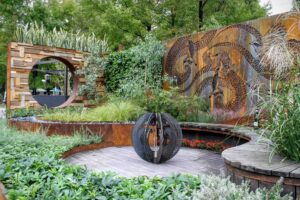 Curved Corten steel sculptural screens featuring wattlebird motifs in contemporary zen garden with fire sphere in Nagasaki