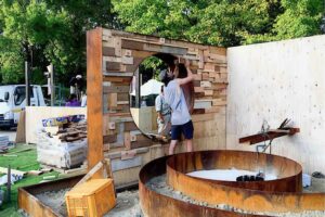 Curved corten steel seating around fire feature with circular window portal in award-winning Nagasaki garden