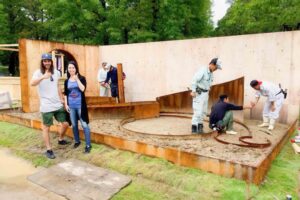 Construction workers building curved timber seating structure with CLT walls for award-winning Wattlebird Garden in Nagasaki