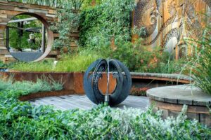 Black perforated spherical water feature with central fountain jet in award-winning Australian garden design in Nagasaki