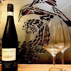 Wine bottle and glasses displayed against decorative wall art featuring bird motifs in award-winning Nagasaki garden