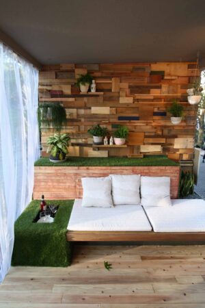 Built-in daybed with reclaimed timber feature wall and artificial turf in small balcony garden design for Nagasaki exhibition
