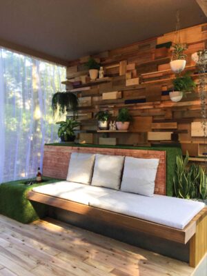 Custom timber daybed with white cushions against living wall with integrated planters in Nagasaki balcony garden