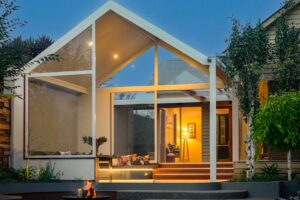 Modern pavilion with fire pit and curved seating at Armstrong Street residence in Ballarat at twilight
