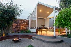 Modern outdoor pavilion with curved corten seating, fire pit and timber details at Armstrong Street Ballarat residence