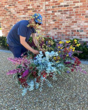 Gardener tending to colourful native plantings including eucalyptus and purple flowering plants at Mount Buninyong property